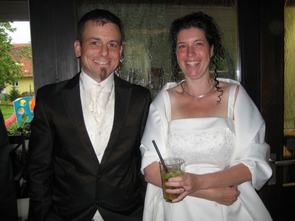 Ehepaar in Brautkleid und Anzug beim Cocktail-Empfang